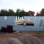 Foundation walls poured and first floor NUDURA ICF walls being stacked. Subfloor on and waterproofing installed.